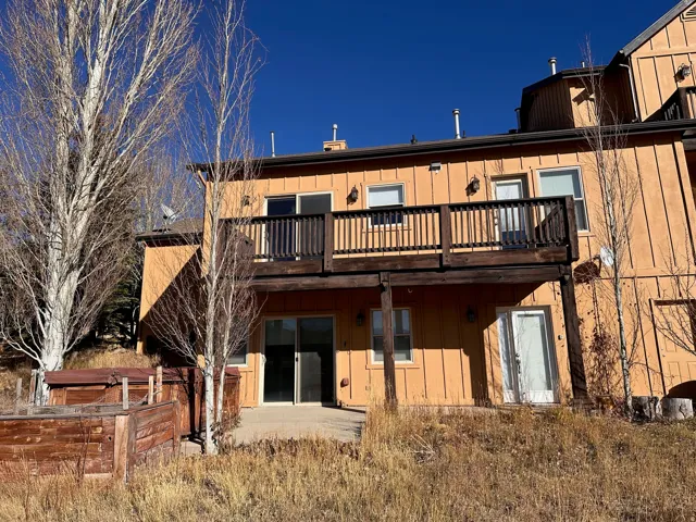 Multi-level property featuring a private upper deck with dark wood railing, offering outdoor access