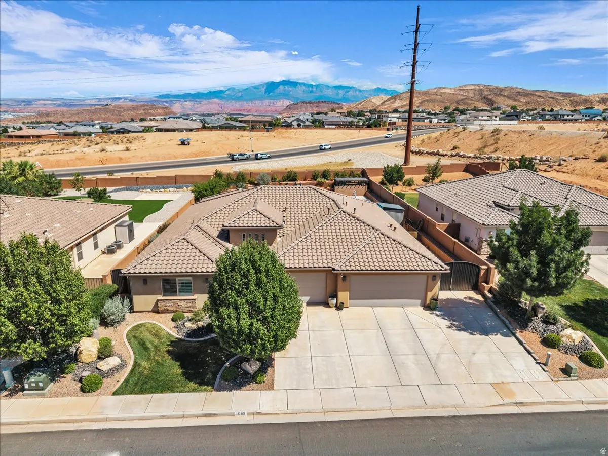Southwestern-style residence featuring a tile roof, an integrated two-car garage, and a concrete driveway