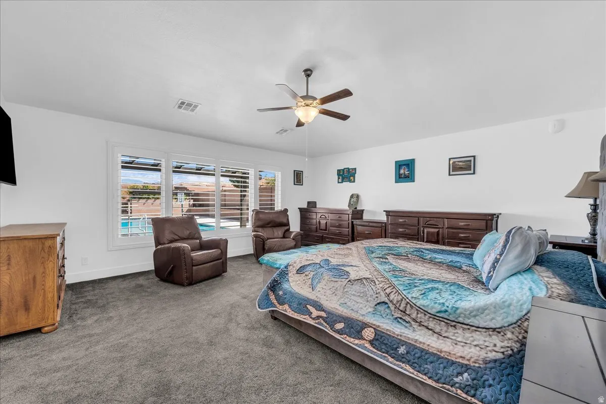 Spacious interior room with white walls and grey carpeting