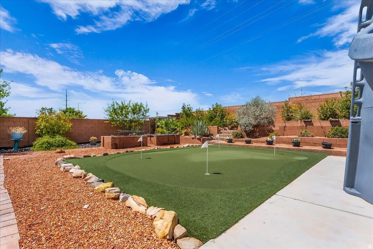 Backyard putting green framed by red rock landscaping