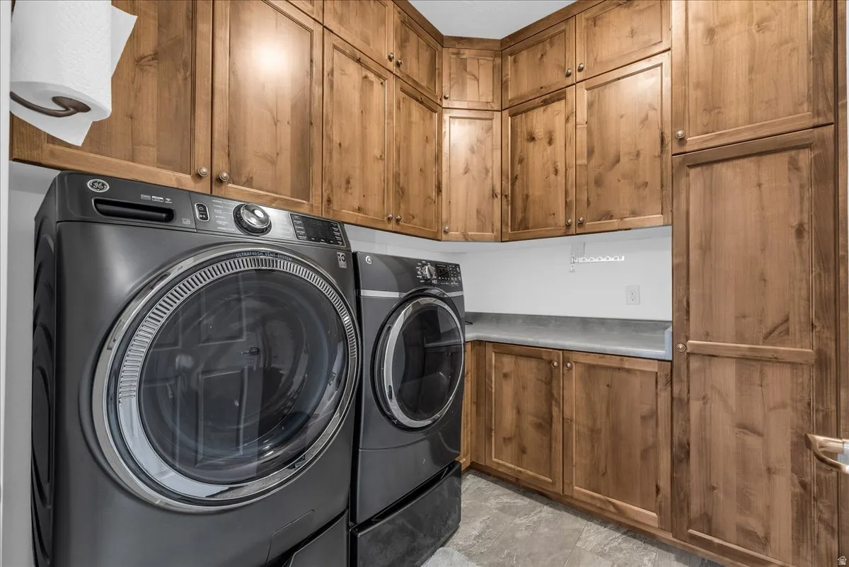 Laundry area featuring extensive wood cabinetry, a built-in counter, and tile flooring