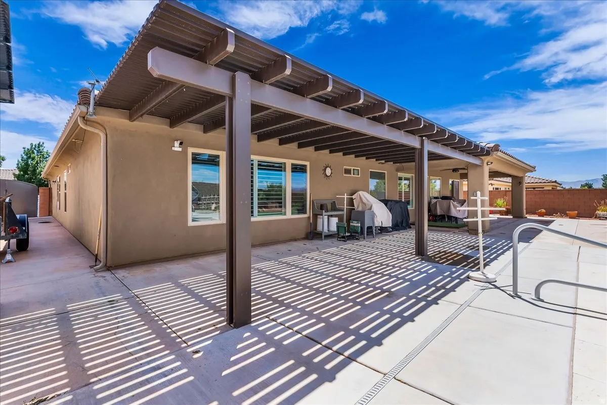 Spacious concrete patio featuring a large pergola and direct access to the interior