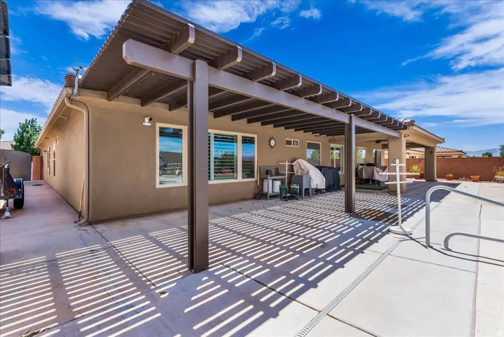 Spacious concrete patio featuring a large pergola and direct access to the interior