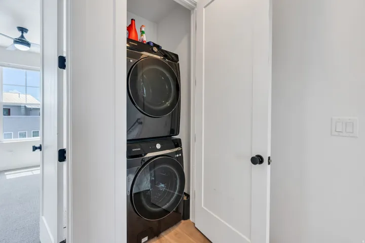 Dedicated laundry closet featuring a stacked washer and dryer unit