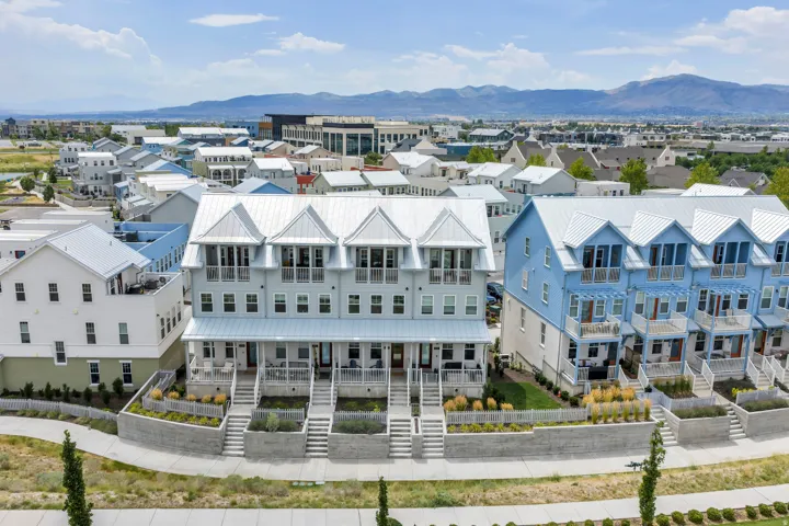 Modern townhome exteriors featuring light blue siding, white trim, and metal roofs