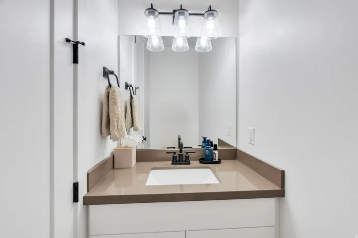 Contemporary vanity featuring a rectangular undermount sink, a neutral-toned countertop, and a matte black faucet