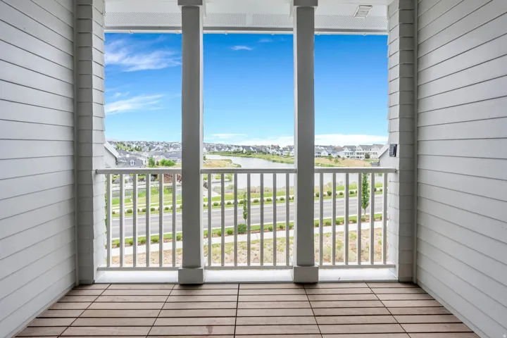 Covered balcony featuring wood-finish flooring and a white railing