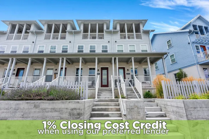 Three-story townhome with a front porch, wood siding, and white exterior railings