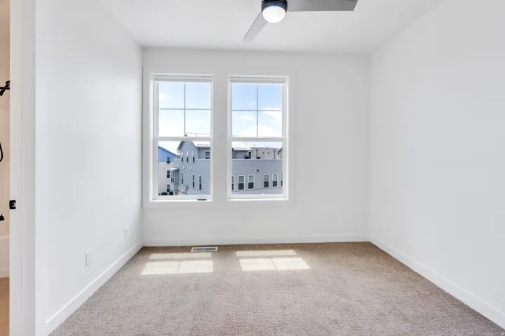 Room featuring a neutral carpet, white walls, and a contemporary ceiling fan