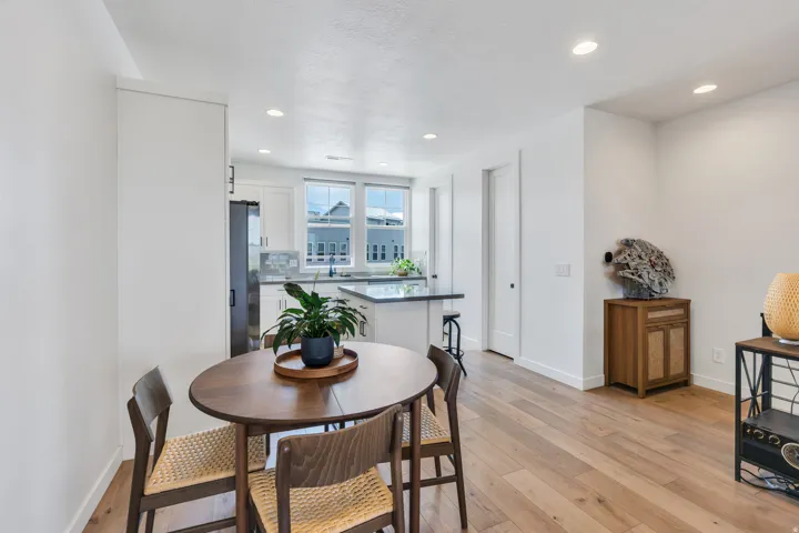Kitchen and dining area featuring light wood-finish flooring, recessed lighting, and white walls
