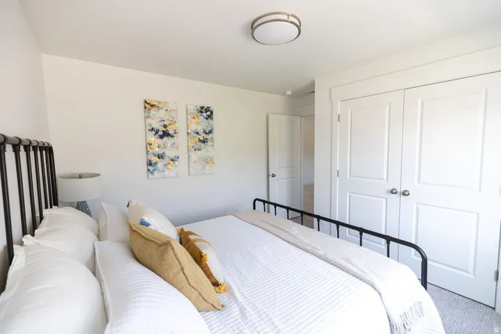 Bedroom featuring a neutral color palette, recessed lighting, and a double-door closet with brushed nickel hardware