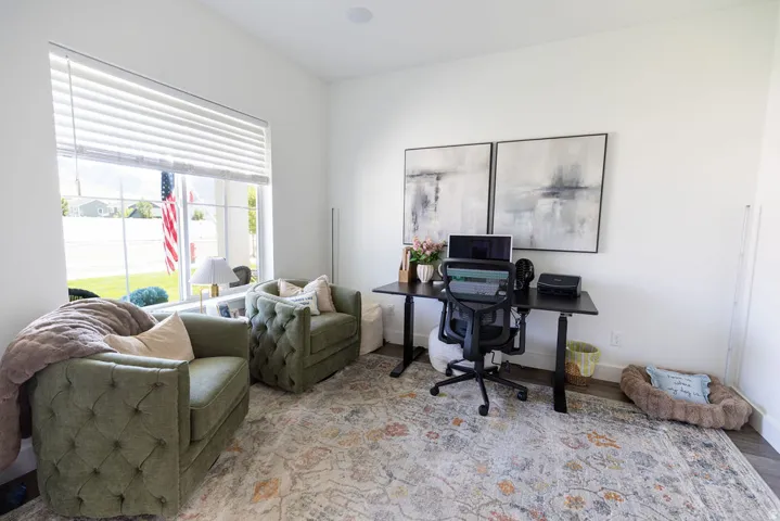 Spacious room featuring a large window with horizontal blinds, providing ample natural light