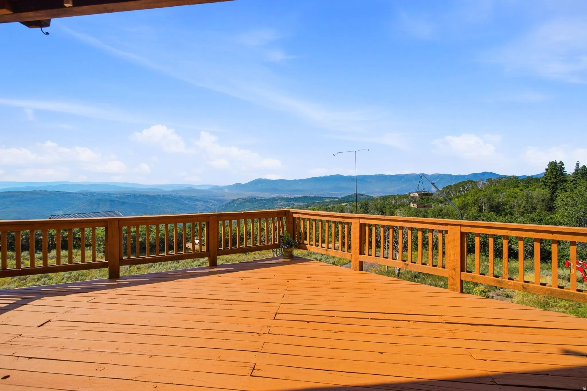 Expansive outdoor deck featuring wood-finish flooring and a wood railing system