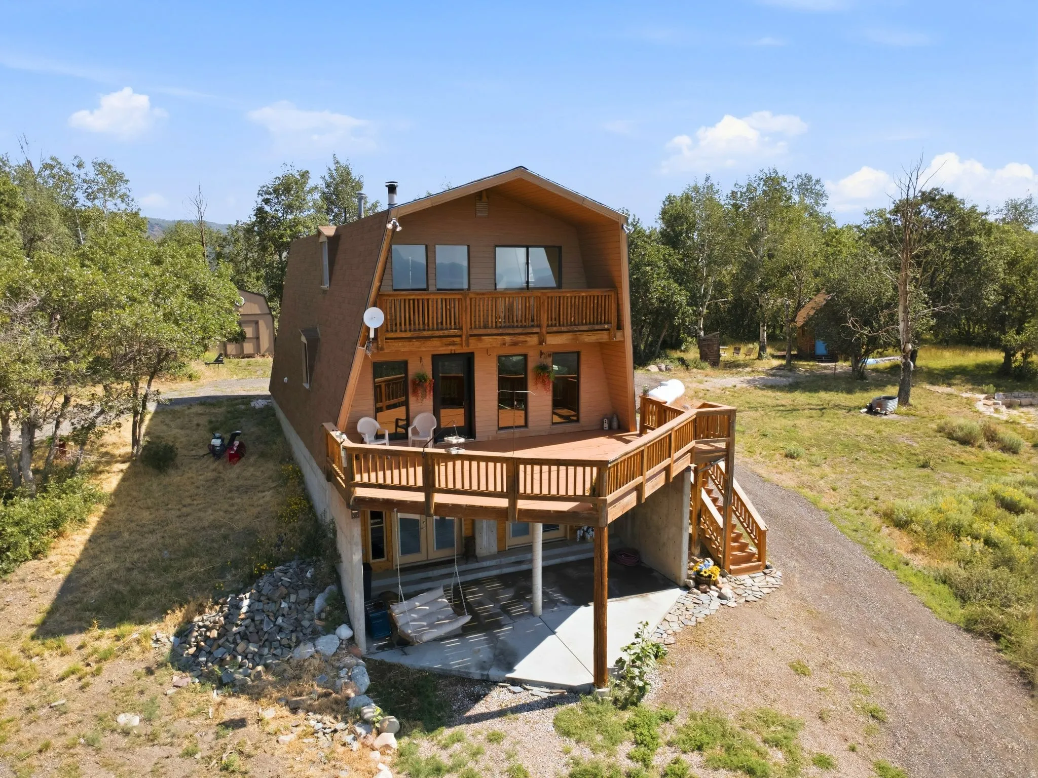 Contemporary A-frame residence featuring a prominent pitched roof and a multi-level deck