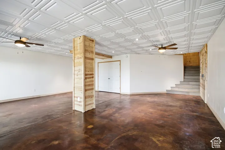 Spacious room featuring distressed concrete flooring and a white coffered ceiling with recessed lighting