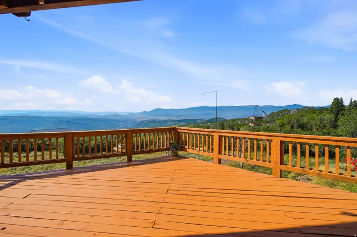 Expansive outdoor deck featuring wood-finish flooring and a wood railing system