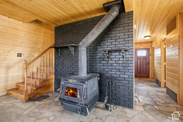 Stairway, Wood-burning stove with a metal flue pipe, set against a dark brick accent wall