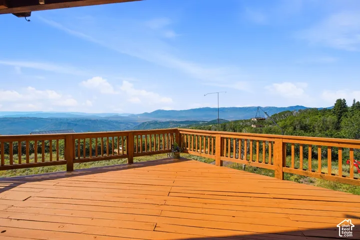 Expansive outdoor deck featuring wood-finish flooring and a wood railing system