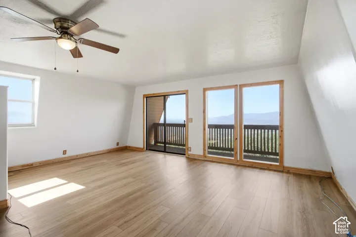 Spacious Primary Bedroom featuring wood-finish flooring, a contemporary ceiling fan, and a large window