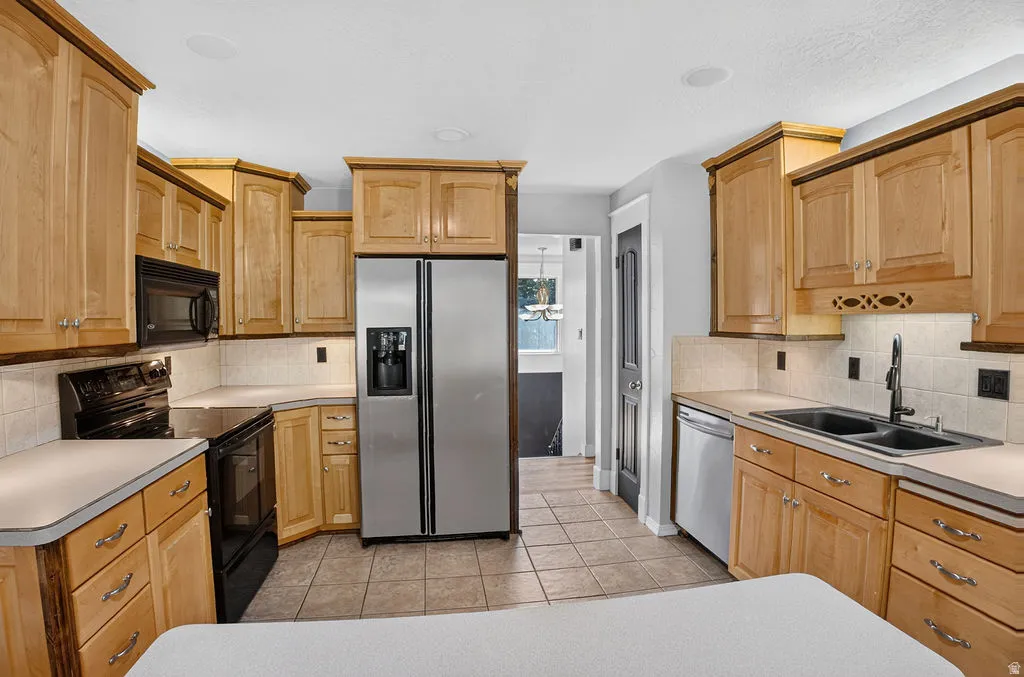 Bright kitchen featuring light wood cabinetry and a tile backsplash