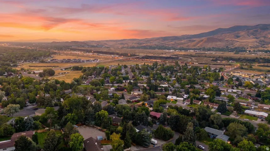 Expansive aerial perspective showcasing a residential neighborhood with varied rooftops and mature tree cover
