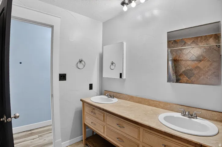 Dual vanity with light wood cabinetry and integrated sinks