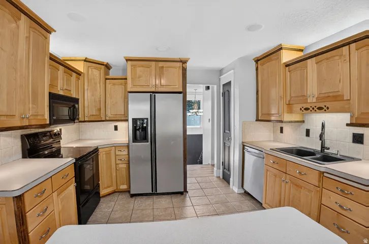 Bright kitchen featuring light wood cabinetry and a tile backsplash