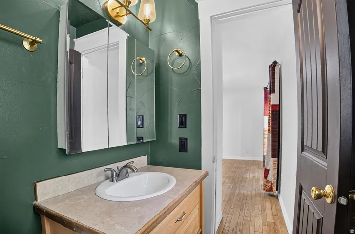 Bathroom vanity featuring a built-in sink, neutral-toned countertop, and wood-finish cabinetry
