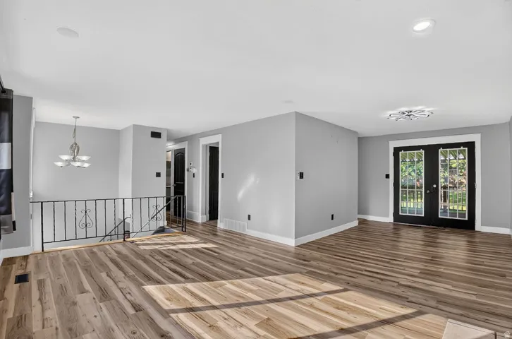 Open common area featuring wood-finish flooring, light gray wall paint, and white trim