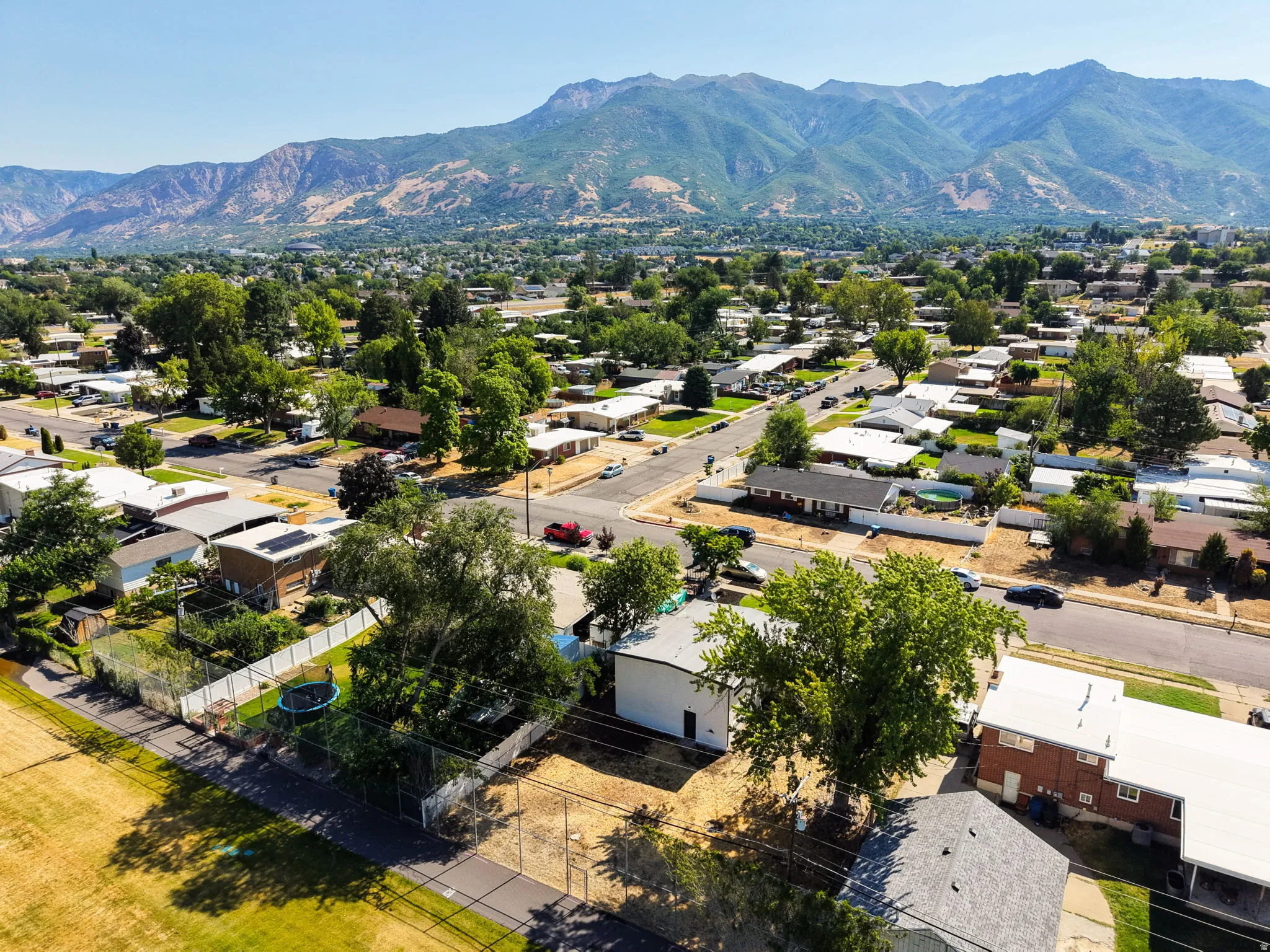 Expansive aerial perspective showcasing a residential neighborhood with a mountainous backdrop