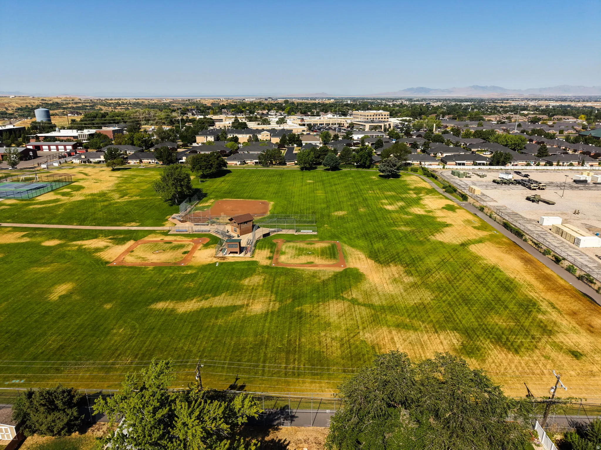 Expansive green space featuring multiple baseball diamonds, a dugout structure, and a backstop