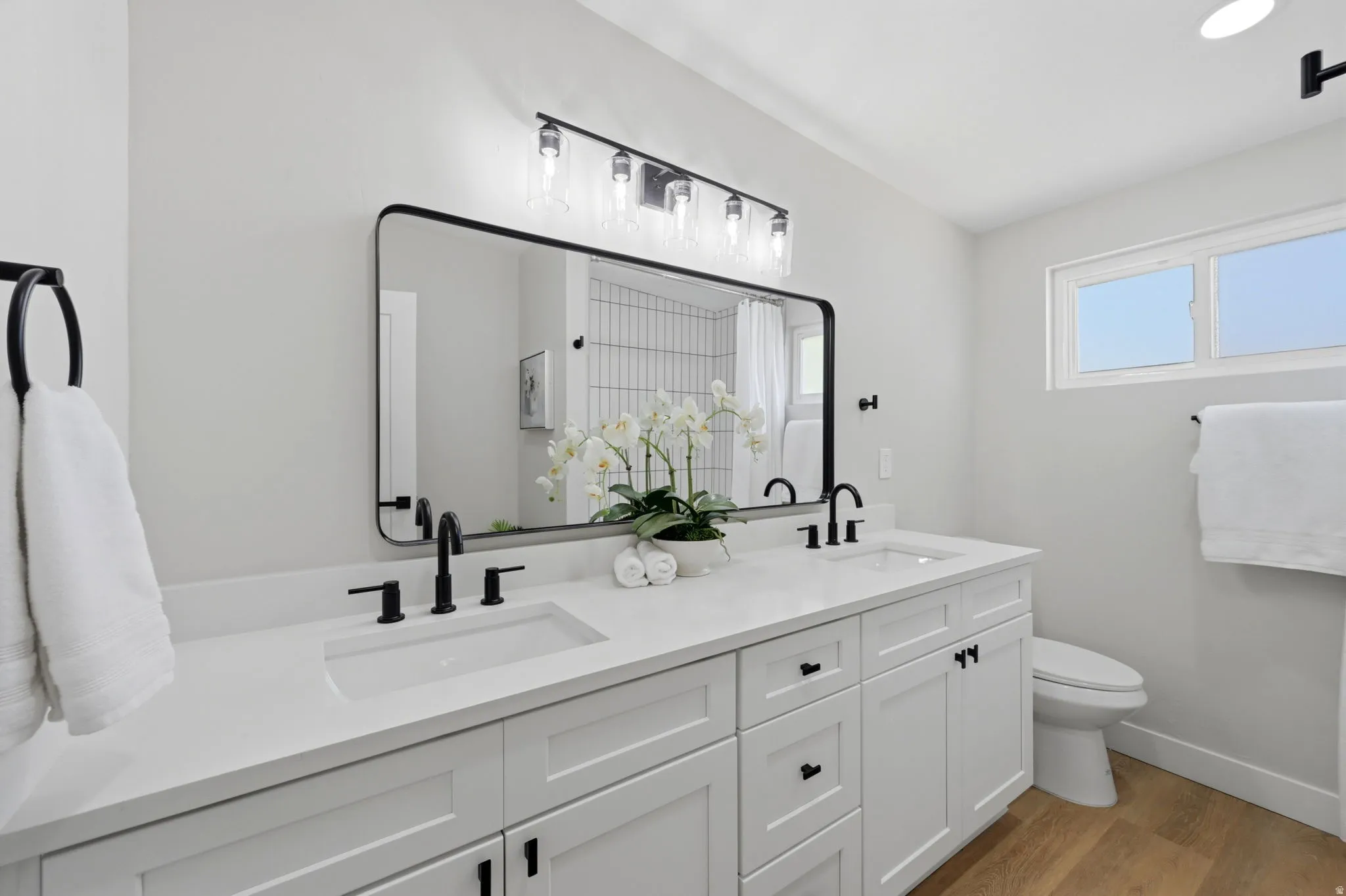 Double vanity featuring white shaker cabinetry and integrated rectangular sinks