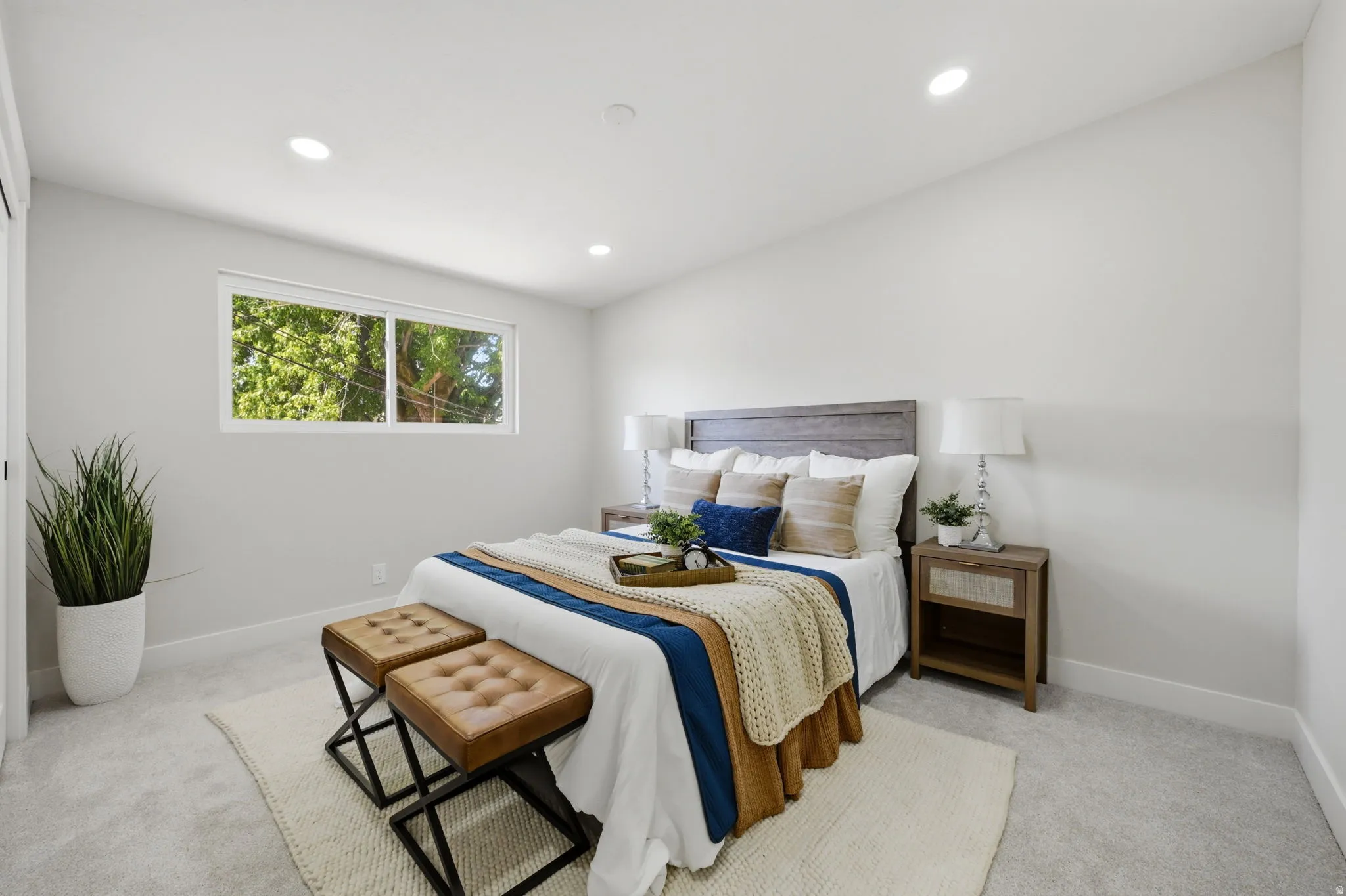 Bedroom featuring light gray carpeting, a horizontal window, and recessed ceiling lighting