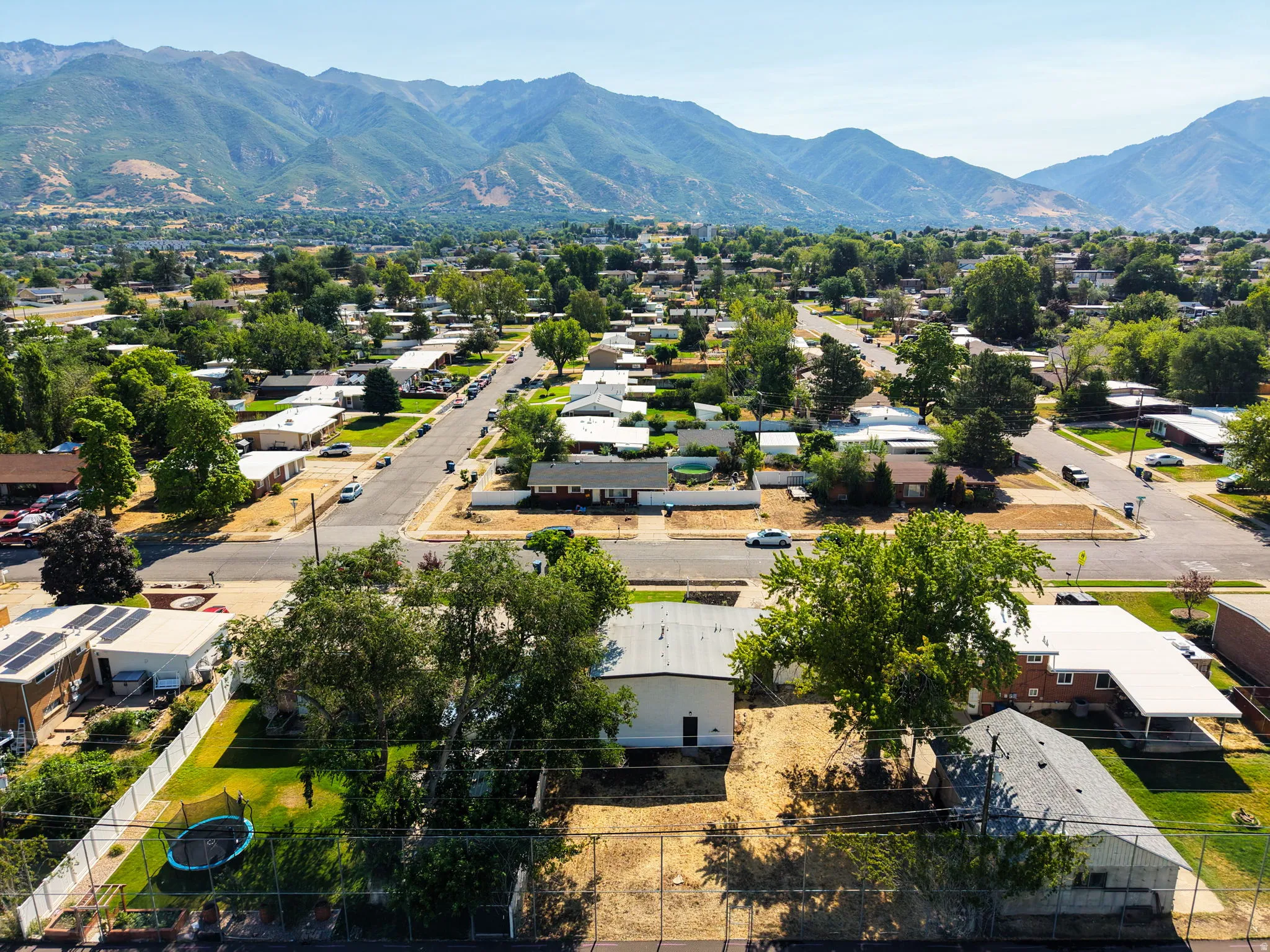 Residential neighborhood featuring mature trees and mountain scenery