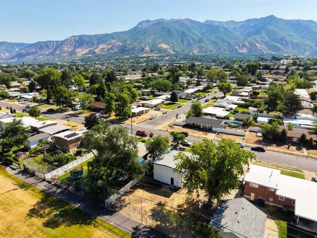 Expansive aerial perspective showcasing a residential neighborhood with a mountainous backdrop