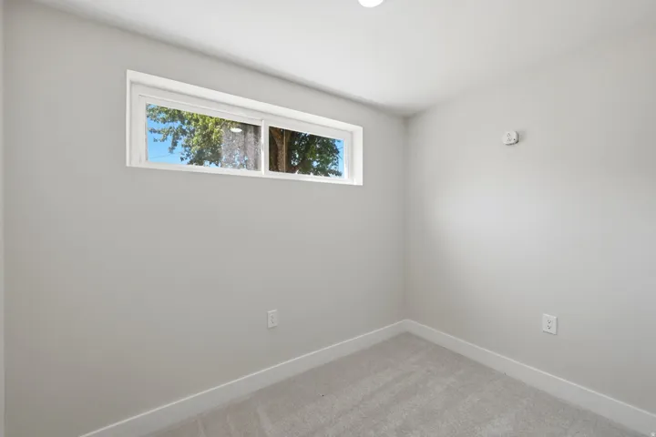 Neutral gray painted walls with white trim and carpeted flooring