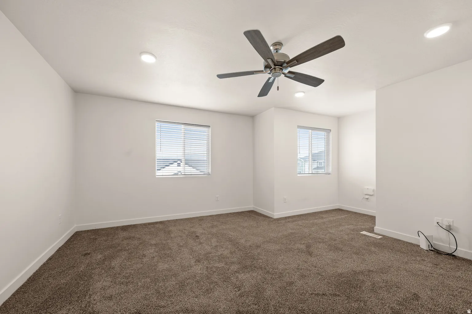 Spacious room featuring neutral carpeting and white walls