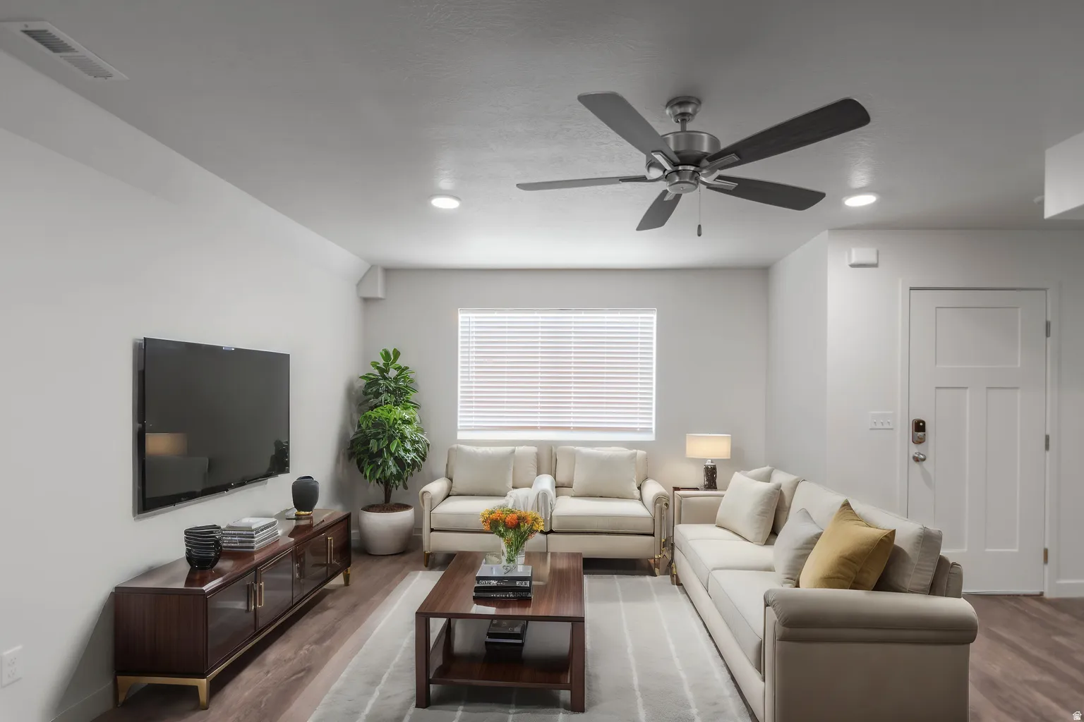 Living area featuring wood-finish flooring, recessed lighting, and a contemporary ceiling fan