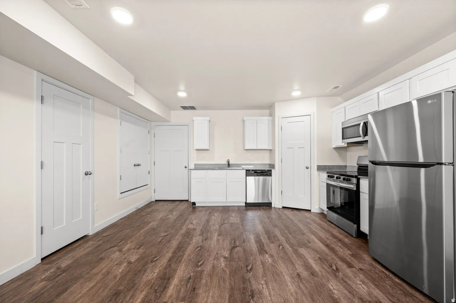 Open concept kitchen area with wood-finish flooring