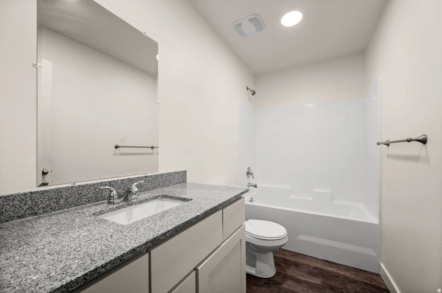 Bathroom featuring a vanity with a light gray speckled countertop, an integrated rectangular sink, and chrome fixtures