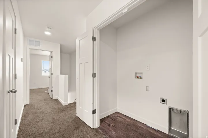 Dedicated laundry area with utility hookups and a stainless steel drain pan
