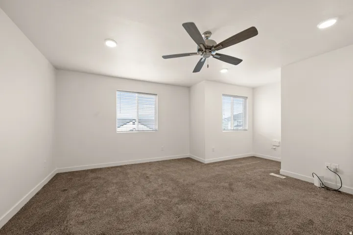 Spacious room featuring neutral carpeting and white walls