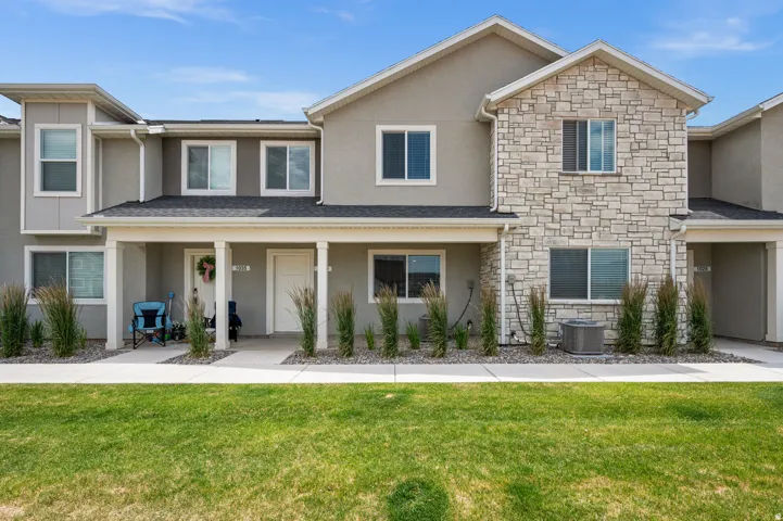 Two-story townhome featuring a stone facade and stucco exterior