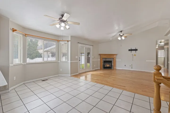 Open-concept living area with a fireplace, wood-finish flooring, and vaulted ceilings