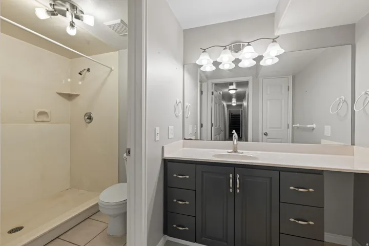 Bathroom featuring a vanity with dark cabinetry, light-toned countertop, and an integrated sink