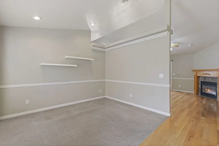 Interior room with light gray walls, white chair rail molding, and two white floating shelves