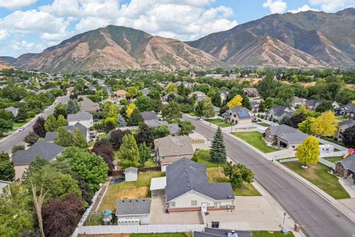 Residential neighborhood featuring mature trees and mountain scenery