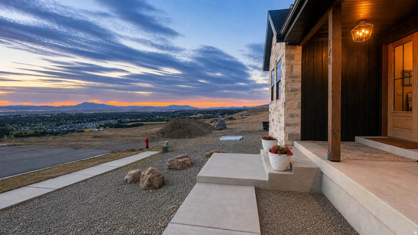 Stone veneer exterior with dark wood siding, concrete porch, and front door with glass inserts