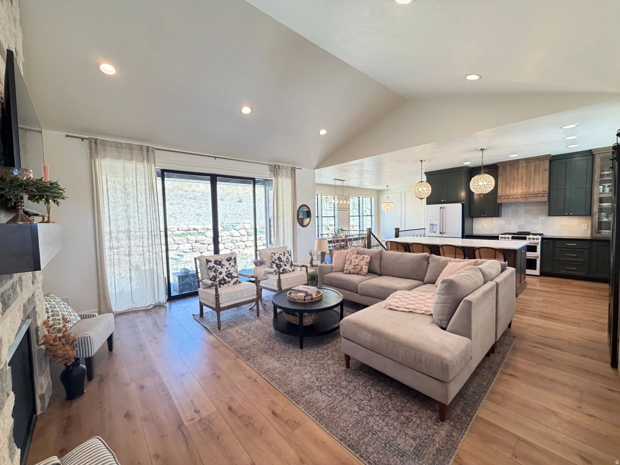 Vaulted ceilings enhance this open-concept living area, featuring wood-finish flooring and recessed lighting
