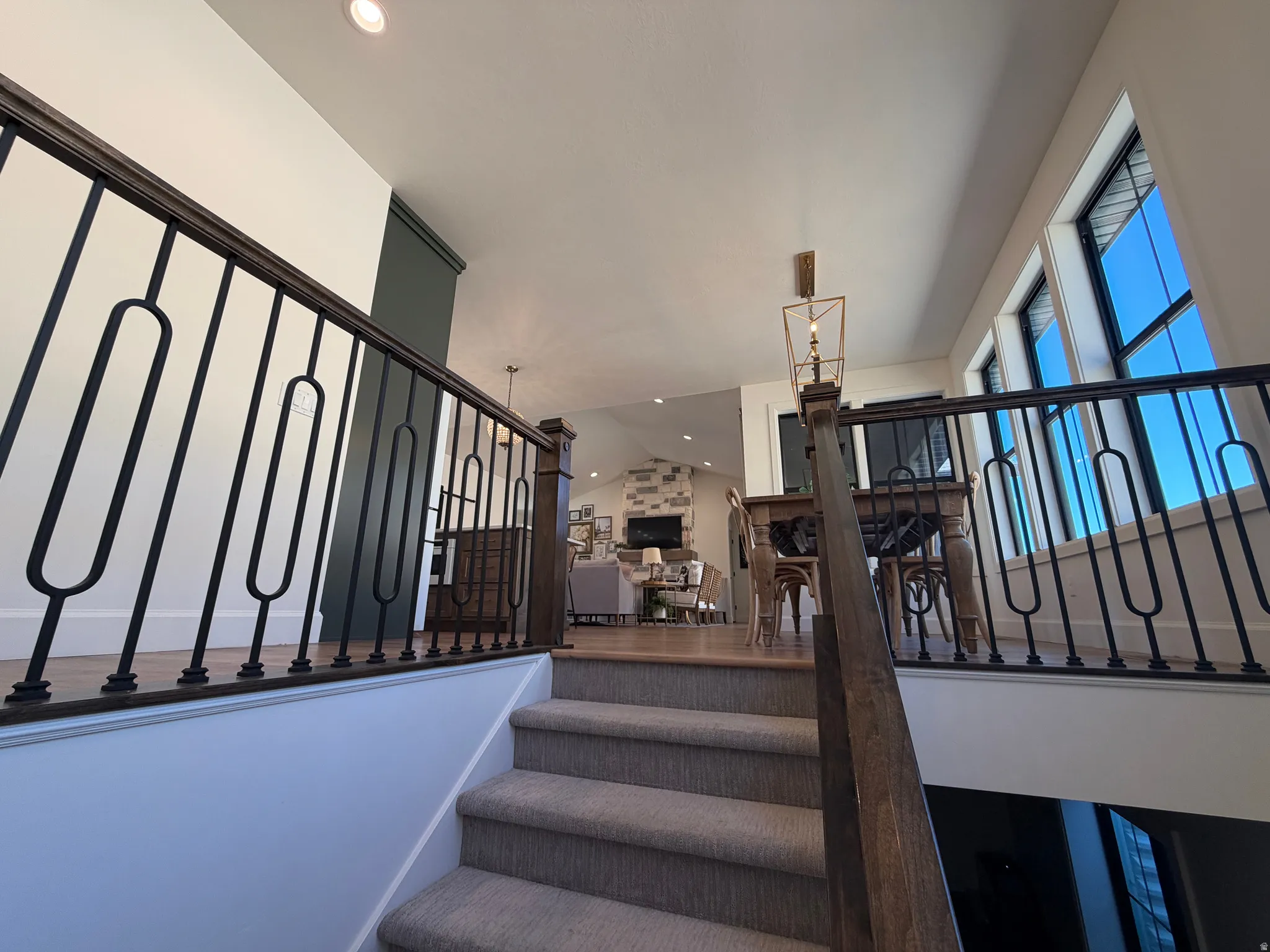 Carpeted staircase with dark wood handrail and decorative metal balusters
